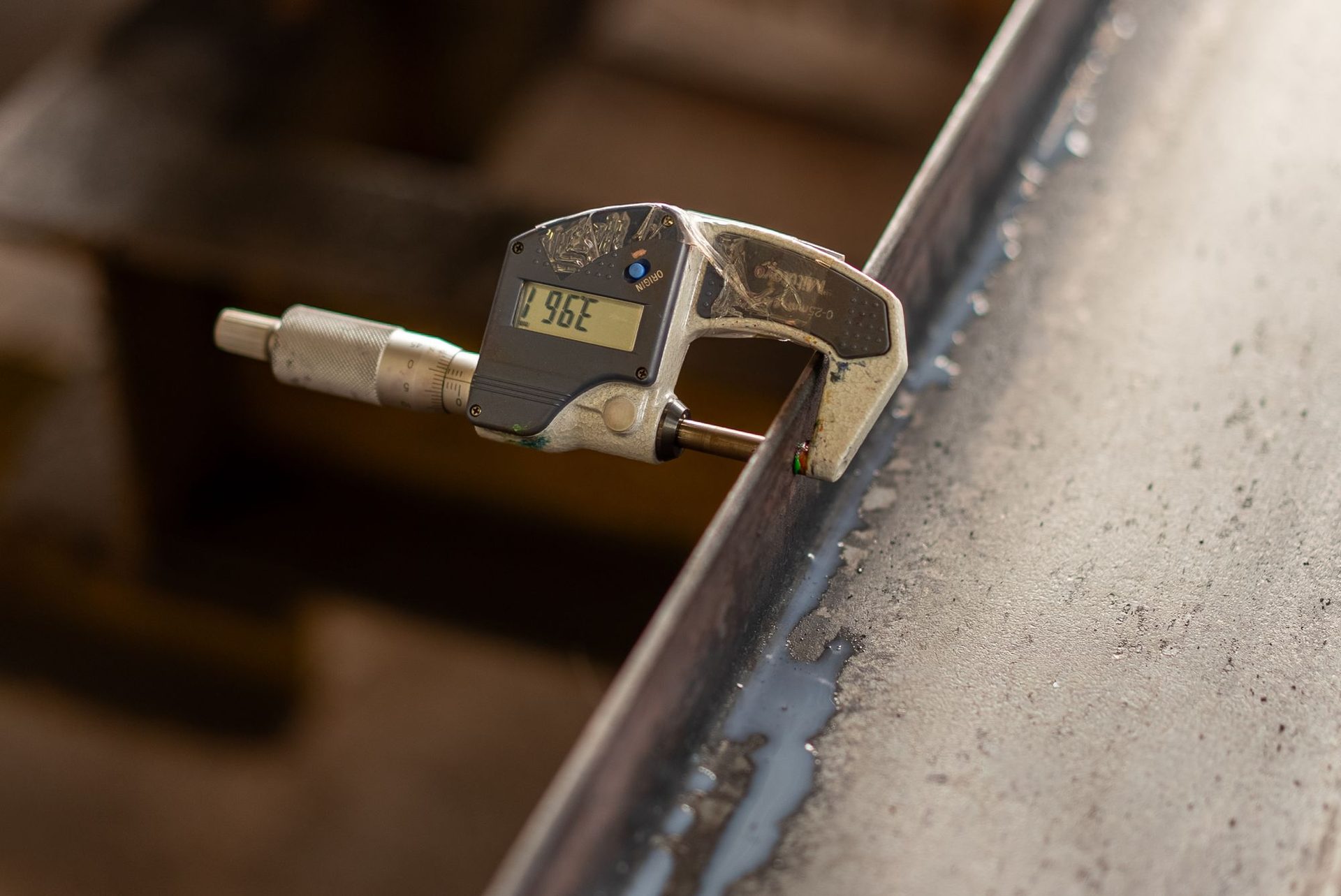 Digital caliper measuring the wall of a machined metal part