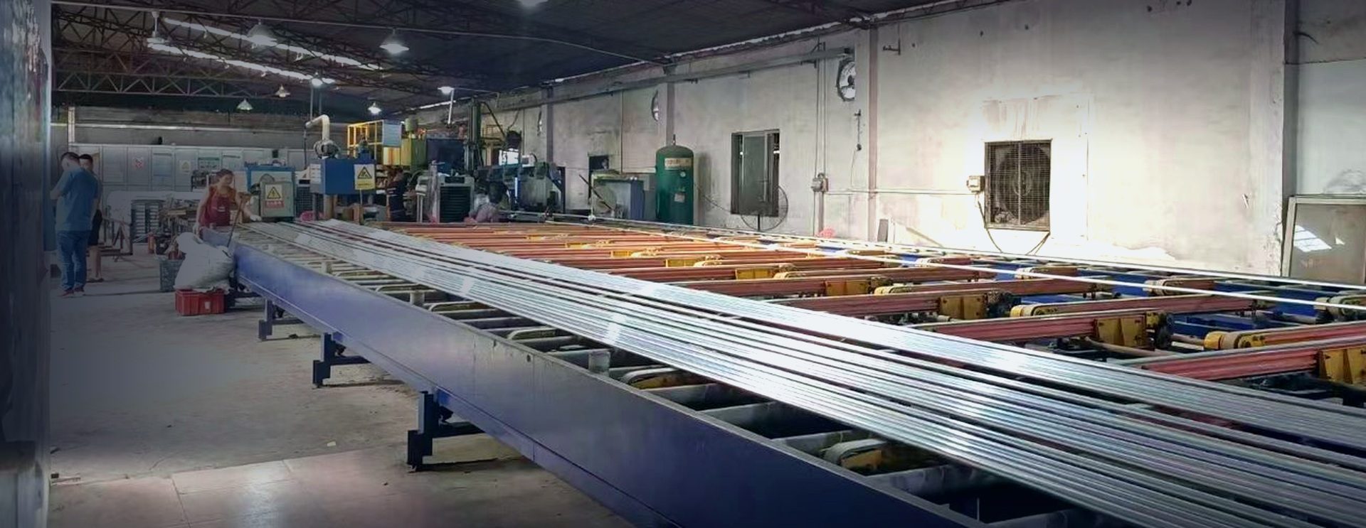 Worker at the control post of an automated aluminum extrusion line in the Shenzhen plant